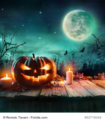 Halloween Pumpkin On Wooden Plank With Candles In A Spooky Night